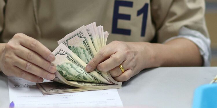 Dollar hovers near two-year high; yuan under threat